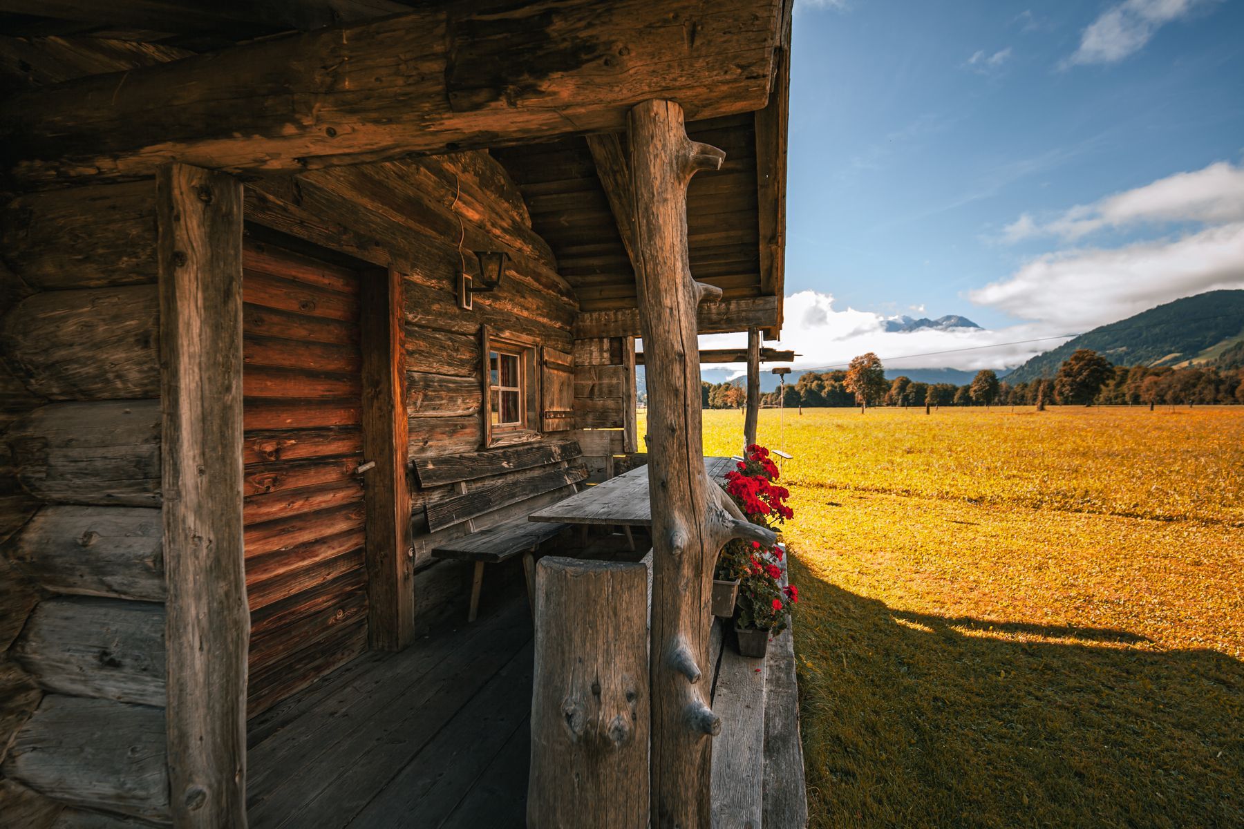 Il portico di legno con la panca e i gerani