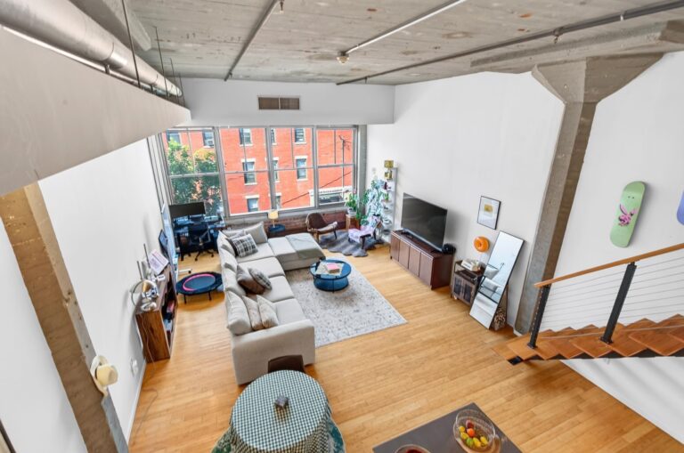 Il soggiorno visto dall’alto, con il soffitto in cemento e le finestre sulla via