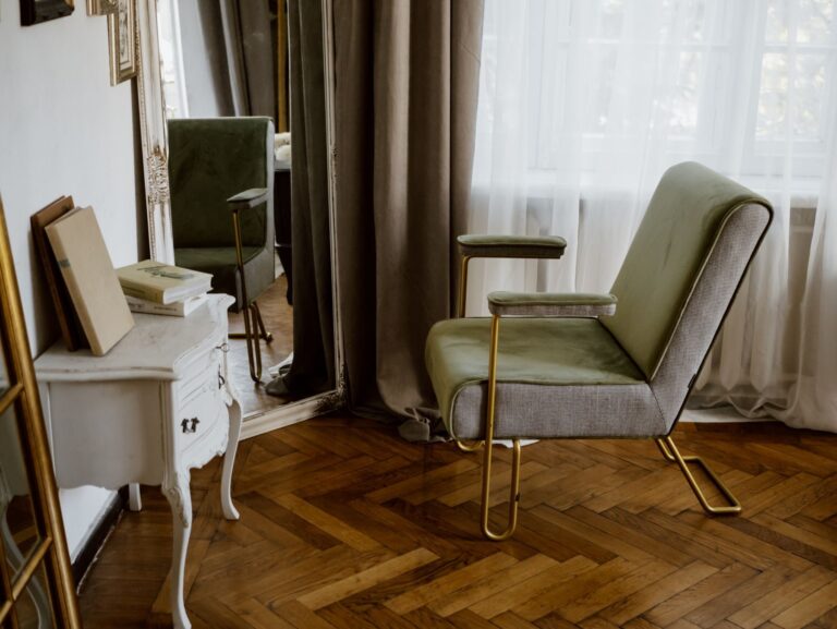 Una poltrona vintage e una console bianca sul parquet a spina di pesce