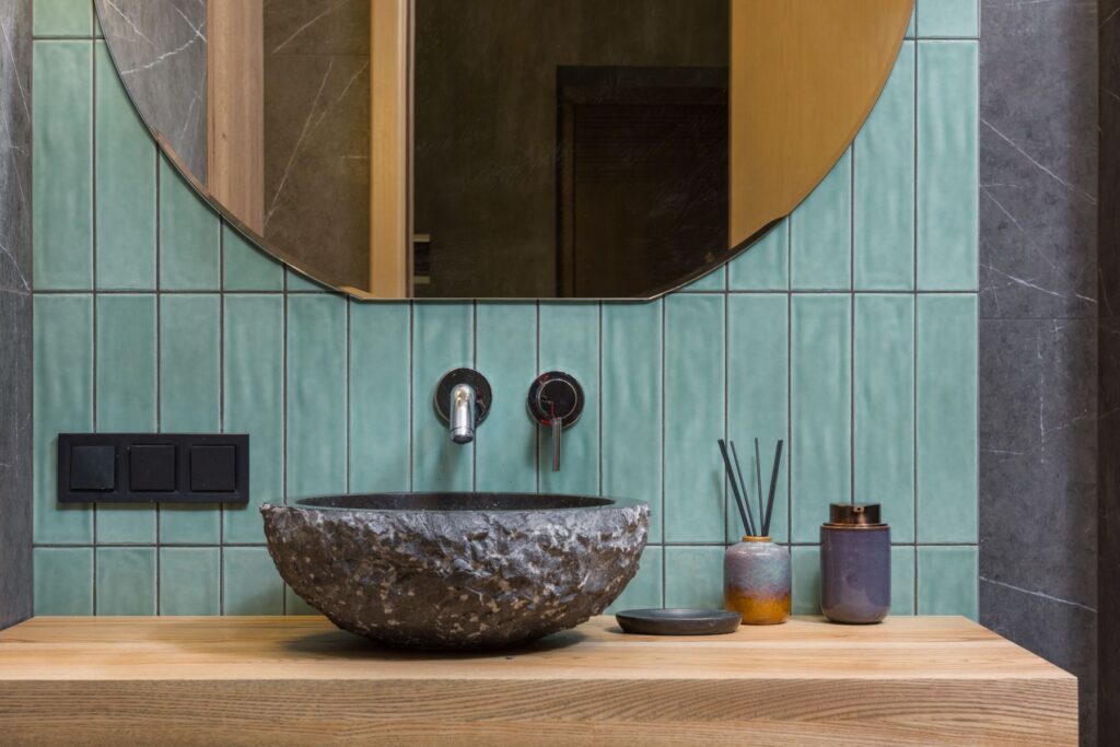 Lavabo in pietra e piastrelle verdi nel bagno