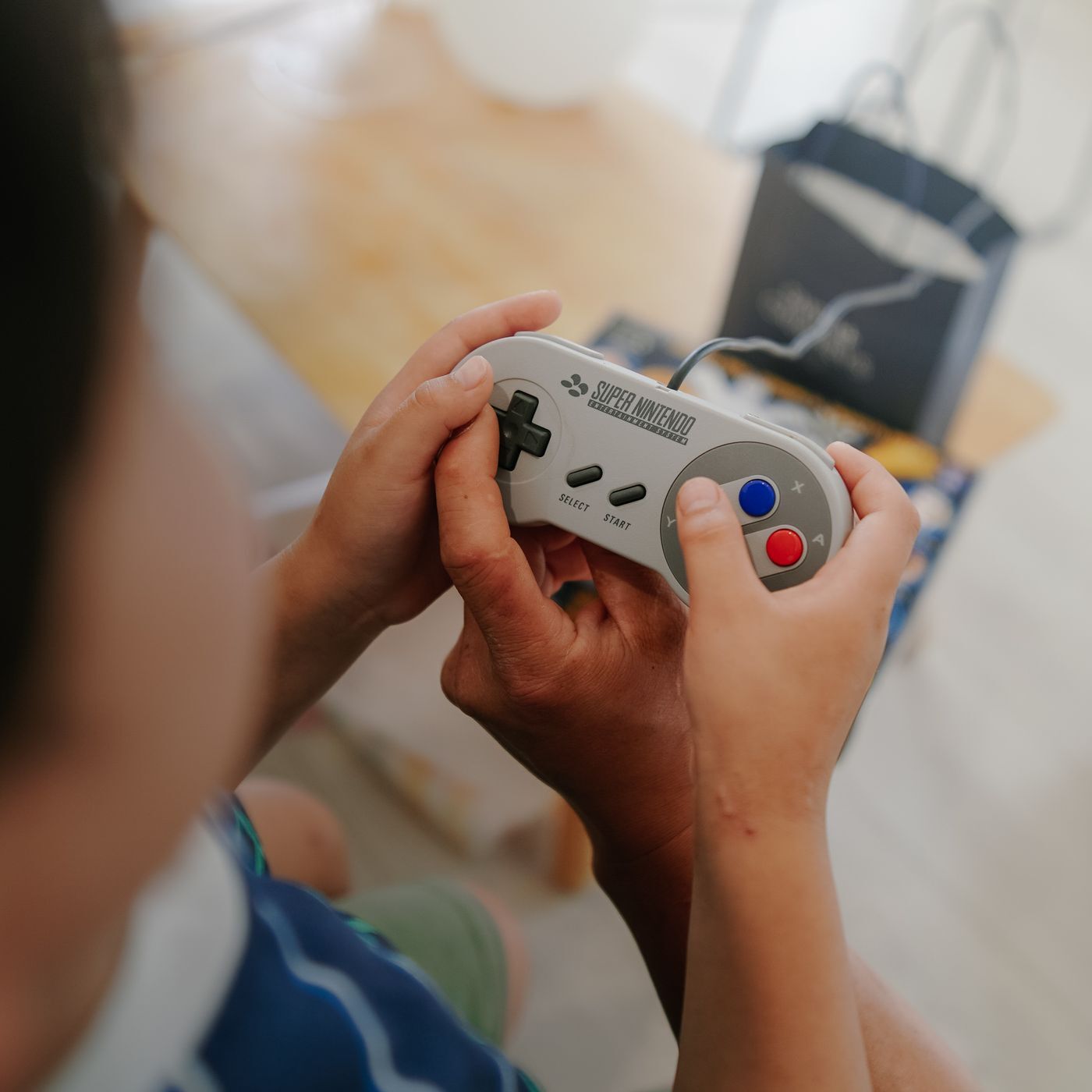 Due mani con il joypad del Super Nintendo