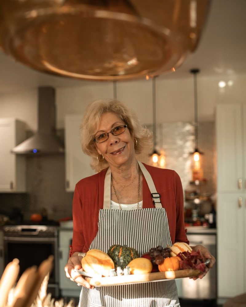 Pina, la nonna, col vassoio del pane in cucina
