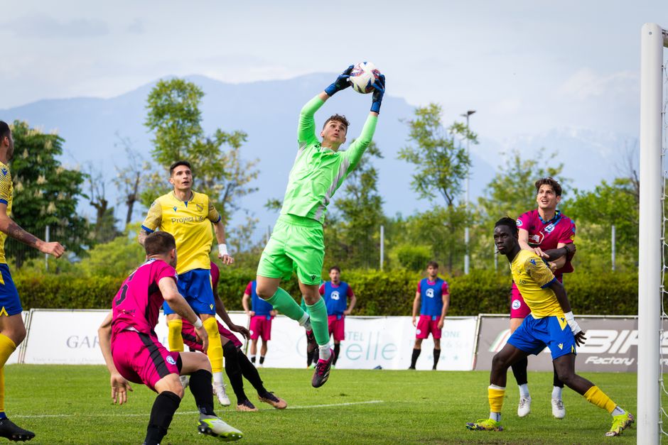 Portero en acción durante un intenso partido de fútbol con jugadores diversos.