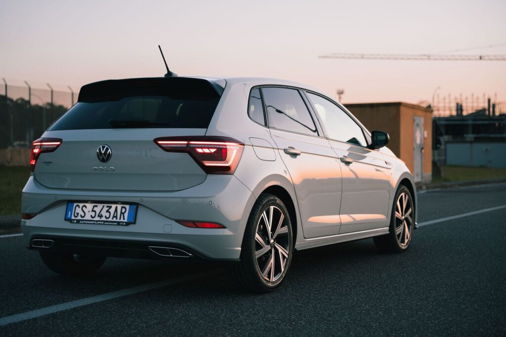 Una Volkswagen Polo bianca vista di tre quarti dal retro, in un parcheggio
