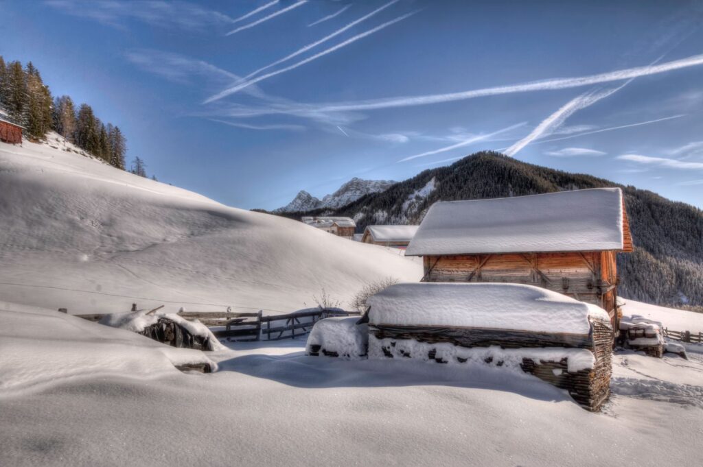 Il tabià coperto di neve, con le travi scure e il tetto a due falde